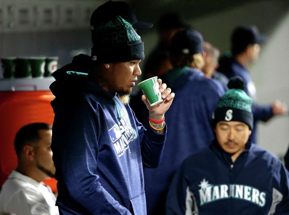 Seattle Mariners pitcher Felix Hernandez, left, stands in the dugout during the ninth inning of the Mariners' baseball game against the Texas Rangers, Tuesday, April 12, 2016, in Seattle. The Rangers won 8-0.