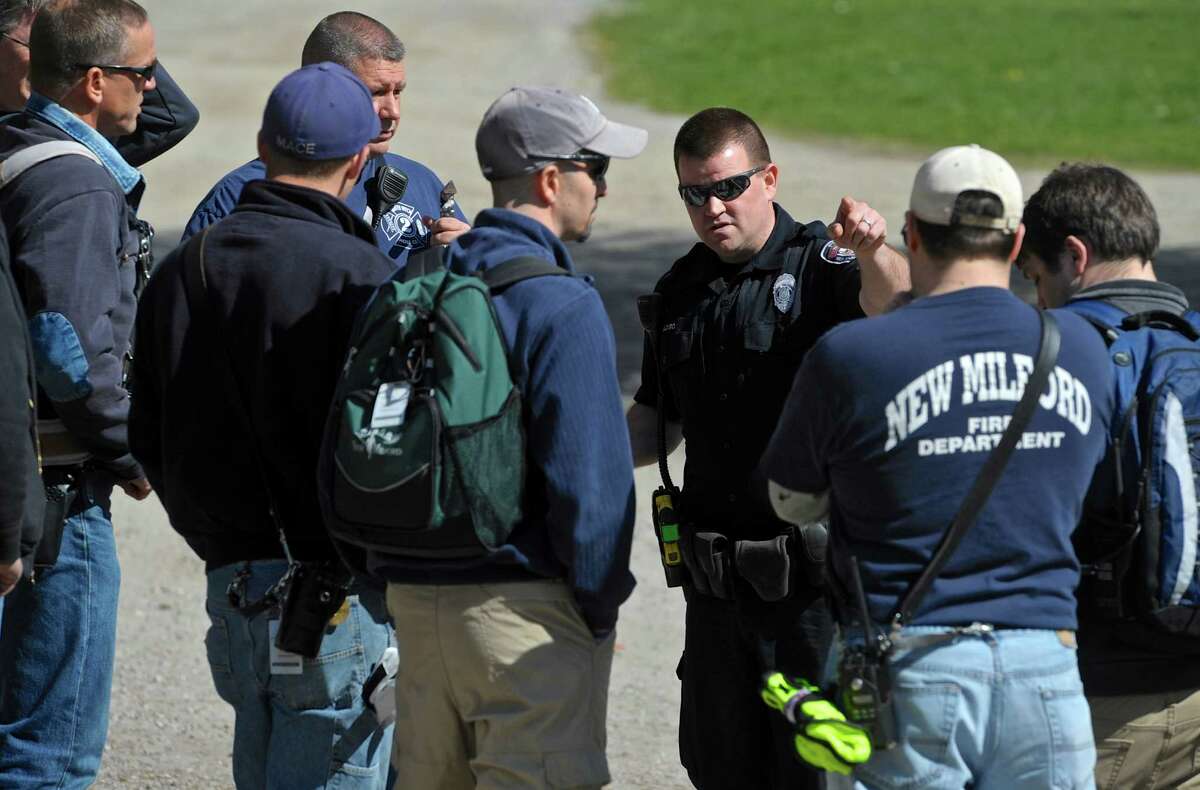 New Milford Police Officer Brian Peloso, center, gives descriptions and names of missing hikers as part of a search and rescue drill in Clatter Valley Park on Saturday, April 16, 2016, in New Milford, Conn. Officer Peloso was first responder on scene for the drill.