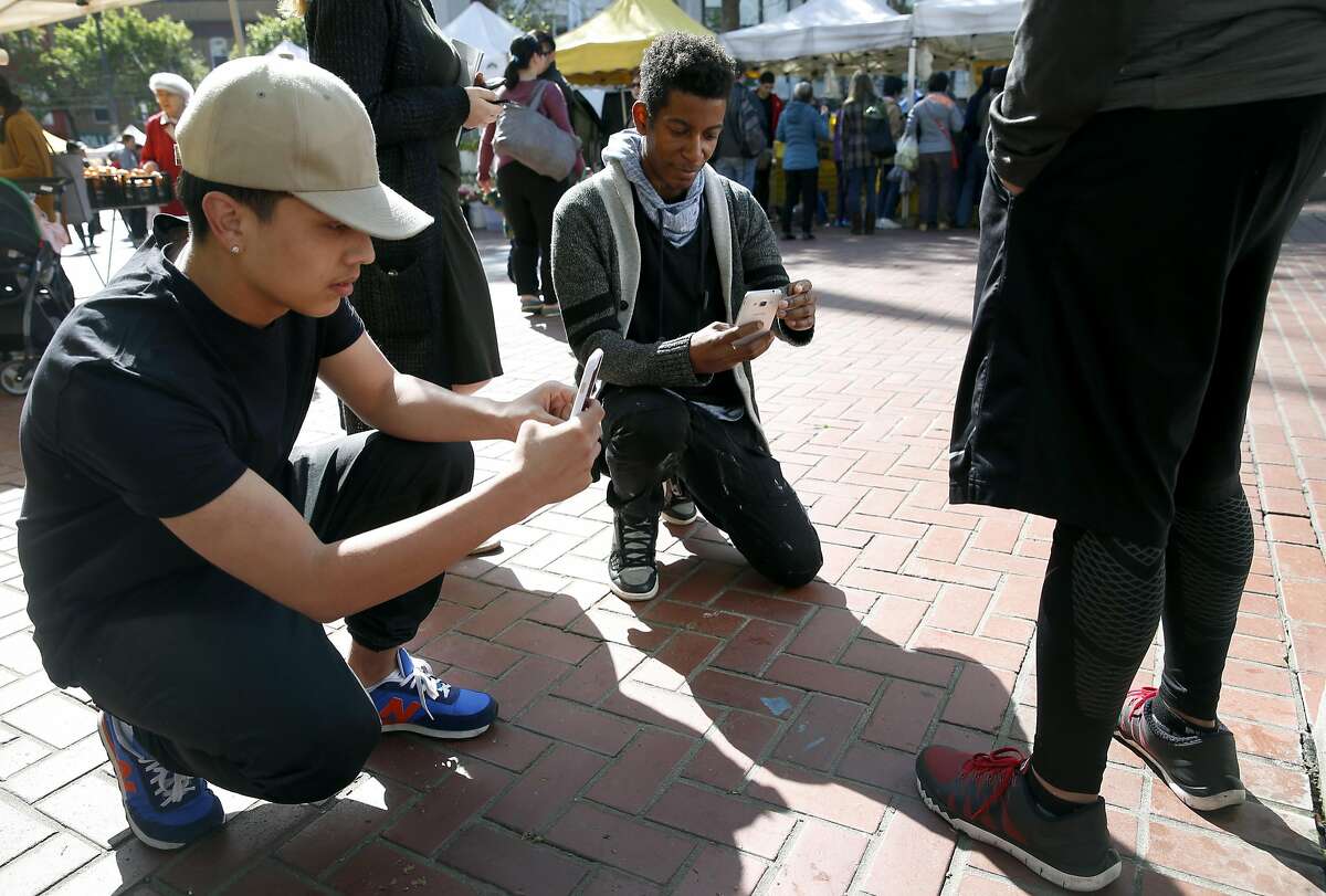 Rigo Concillion and Elishes Cavness photograph shoes while on the lookout for fashion trends at the UN Plaza Farmers Market for a class run by Mikel Rosen at the Art Institute of California in San Francisco, Calif. on Wednesday, April 13, 2016.