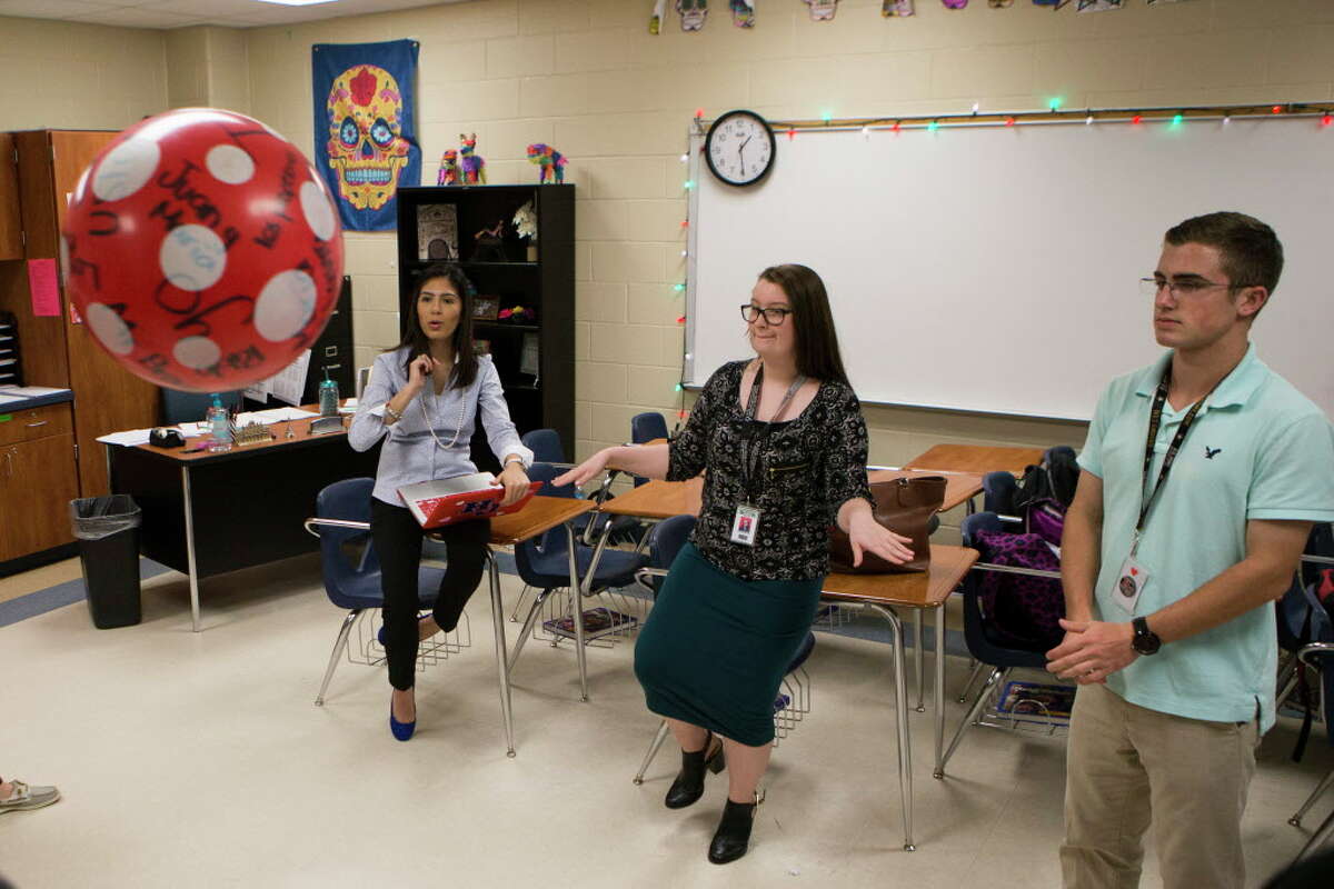 Hardin Jefferson High School Spanish language teacher Ana Rocha, second from the left, 26, interacts with her students, Breanna Kelley, center, 16, and during a language exercise on which the student who gets stuck with the ball after the music stops has to a create conditional sentence from the verb provided by the teacher. Since Rocha qualified for President Barak Obama's temporary work permit known as deferred action for childhood arrivals, Rocha has health insurance, contributes to Social Security and began to drive.