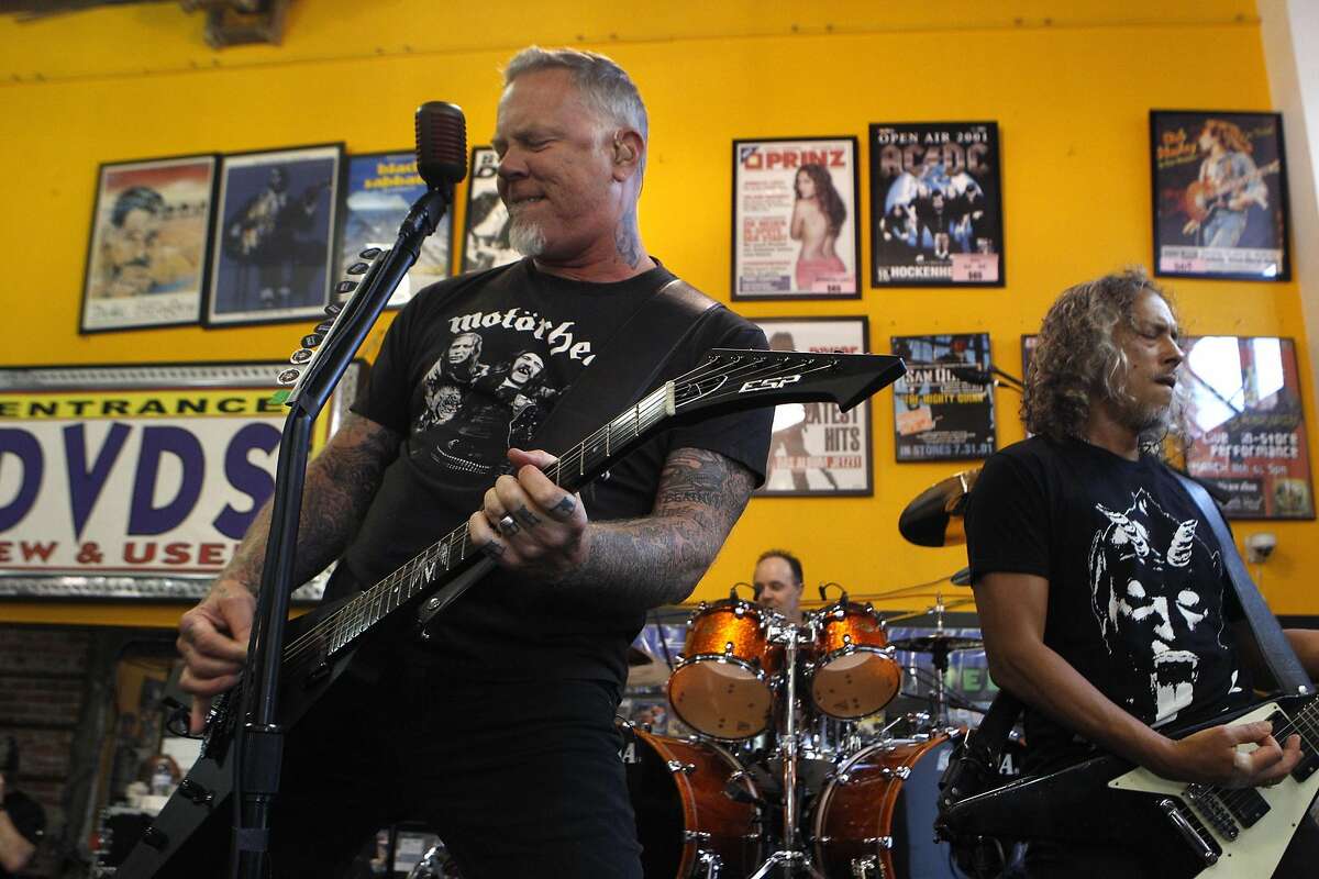 Guitarists James Hetfield, left, Lars Ulrich, center, and Kirk Hammett play on stage for Metallica's live performance at Rasputin Records in Berkeley, Calif., on Saturday April 16, 2016