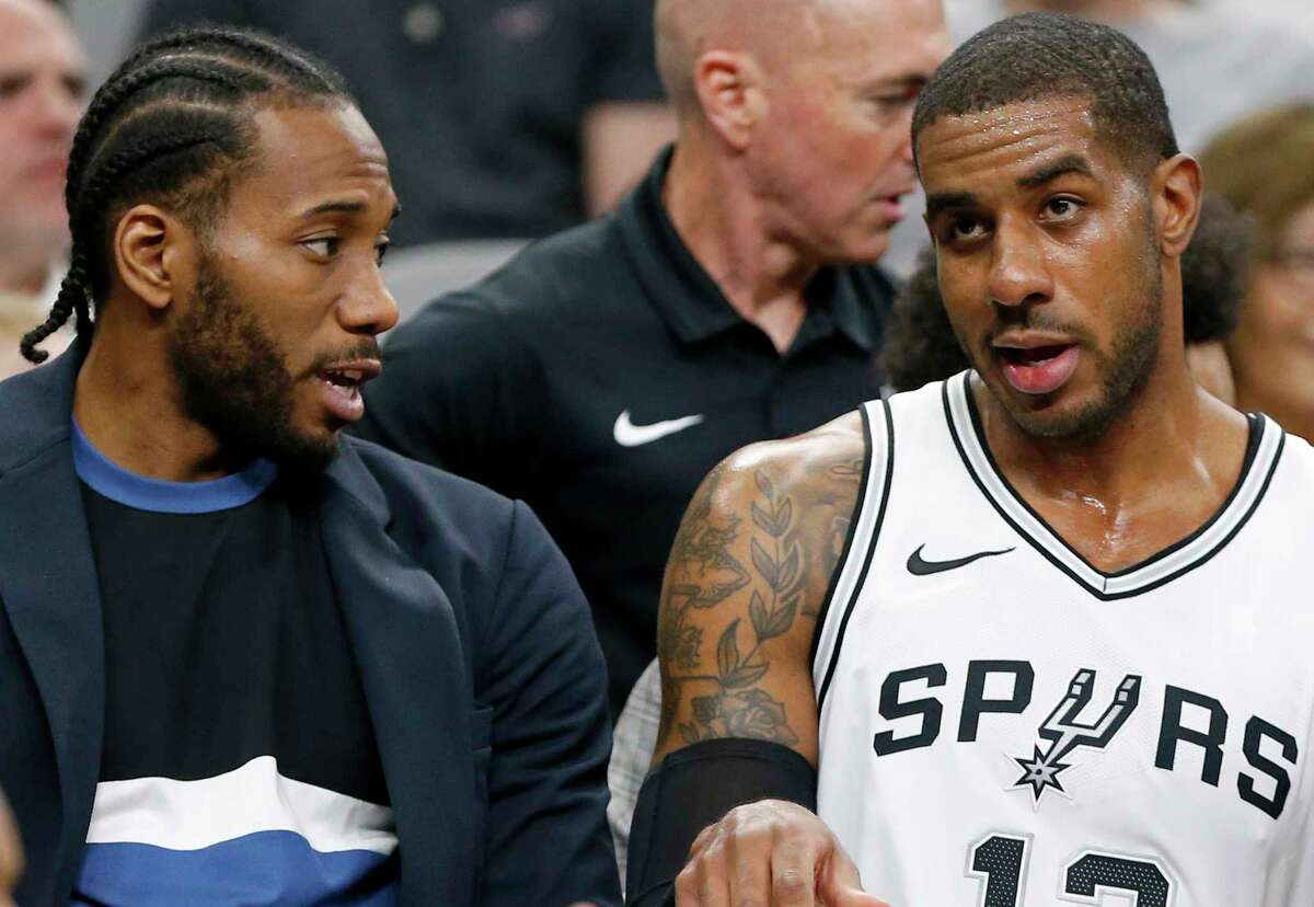 San Antonio Spurs forward Kawhi Leonard — pictured here talking with LaMarcus Aldridge on the bench during first half action against the Memphis Grizzlies Monday March 5, 2018 — said Wednesday, March 7, 2018, that he intends to finish his career as a Spur and also said he hopes to get back on the court "soon," although he doesn't have a set date for his return.