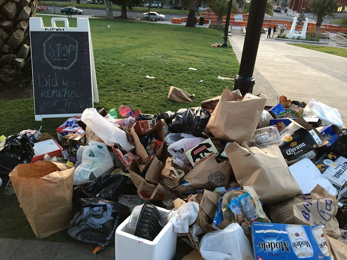 Dolores Park was littered with trash on the morning of Monday, April 18, 2016, after the weekend's warm weather attracted large crowds. Here a heap of trash is pictured next to a sign asking park-goers to pack out their trash.