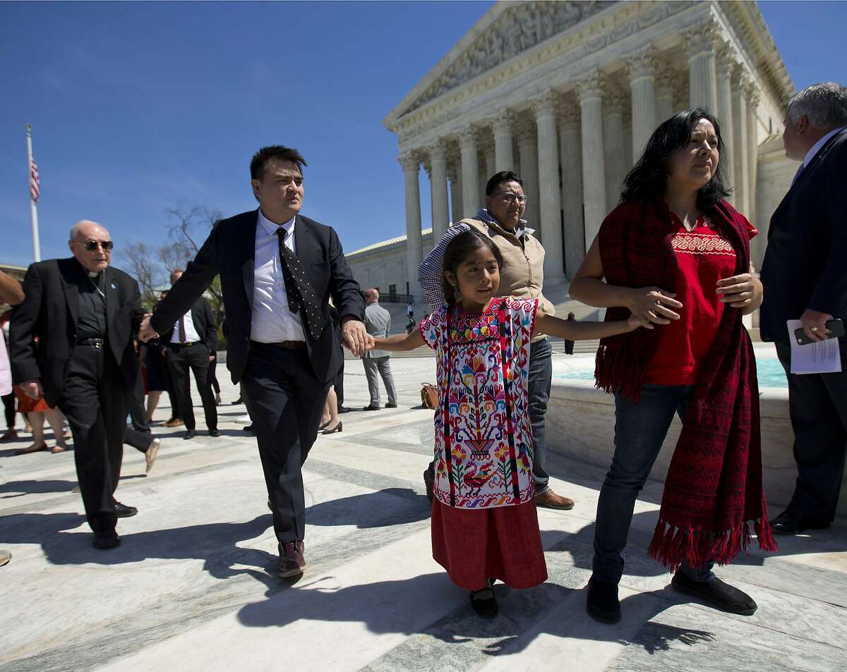 From left, Archbishop Emeritus of Washington Cardinal Theodore McCarrick, Jose Antonio Vargas, a journalist, filmmaker, and immigration rights activist from San Francisco, Sophie Cruz, 6, and her mother Zoyla Cruz, both from Los Angeles, all hold hands as they walk over to address members of the media outside the Supreme Court in Washington, Monday, April 18, 2016. The Supreme Court is taking up an important dispute over immigration that could affect millions of people who are living in the country illegally. The Obama administration is asking the justices in arguments today to allow it to put in place two programs that could shield roughly 4 million people from deportation and make them eligible to work in the United States. 