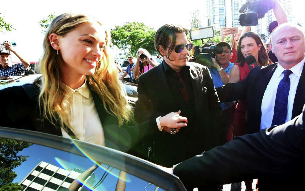 Johnny Depp, center, and wife Amber Heard, left, arrive at the Southport Magistrates Court on the Gold Coast, Australia, Monday, April 18, 2016. Heard pleaded guilty to providing a false immigration document amid allegations she smuggled the couple's dogs into Australia. (Dave Hunt/AAP Image via AP) NO ARCHIVING, AUSTRALIA OUT, NEW ZEALAND OUT, PAPUA NEW GUINEA OUT, SOUTH PACIFIC OUT