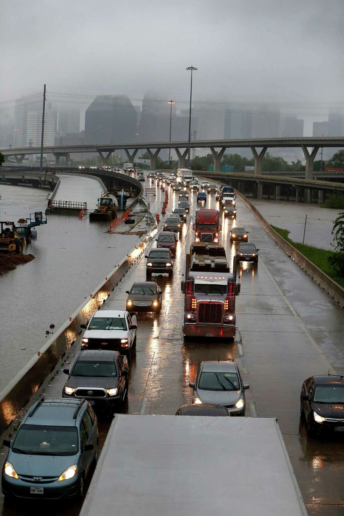 Cars creep north on I-45 North﻿ as floodwaters surround them near downtown at Quitman Street as White Oak Bayou came out of ﻿its banks Monday﻿.