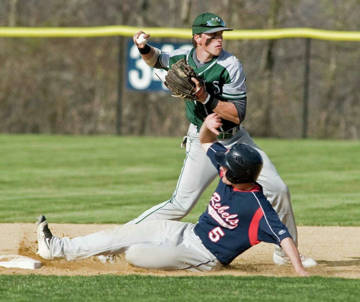 New Milford’s Jackson Olson fires the ball to first trying for the double play as New Fairfield’s Tyler Hart slides into second on Monday.