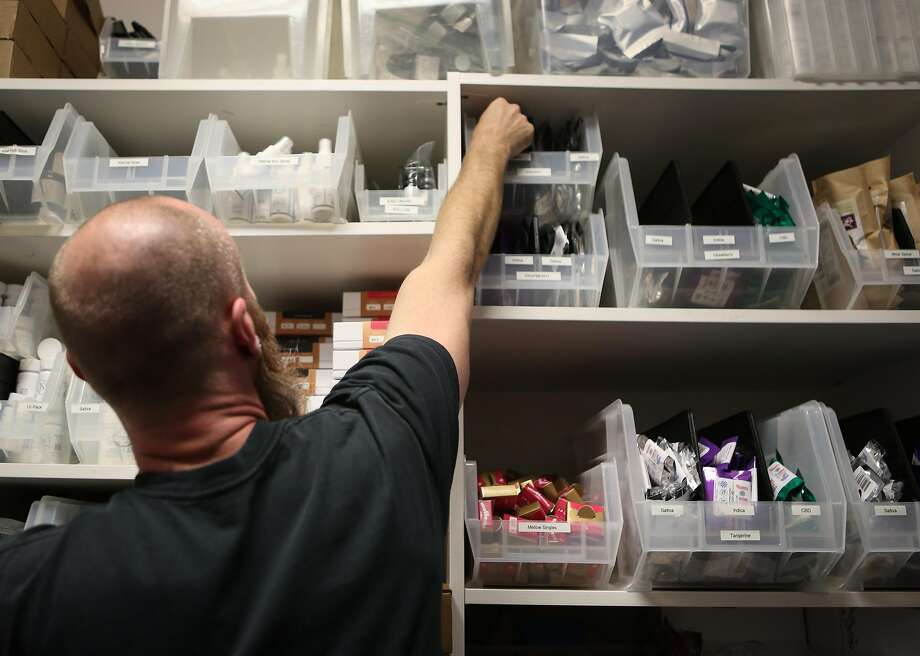 Patient consultant Eric Crawford of the Apothecarium, a marijuana dispensary, stocks bins containing marijuana edibles for an upcoming 420 event to celebrate cannabis in April 2016. Photo: Amy Osborne, Special To The Chronicle