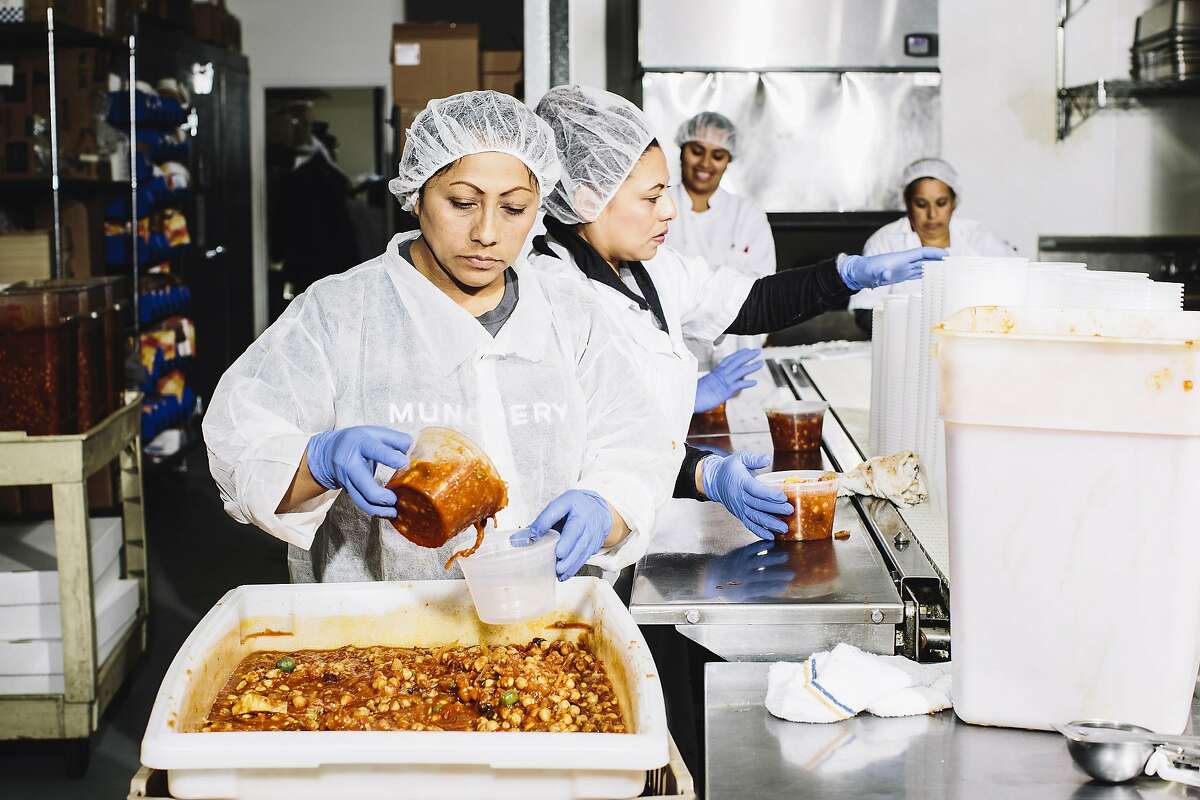 Teresa Chable, a kitchen worker at Munchery, pours olive chickpea stew into a container at the company's kitchen in San Francisco, Calif. on Tuesday, April 19, 2016.
