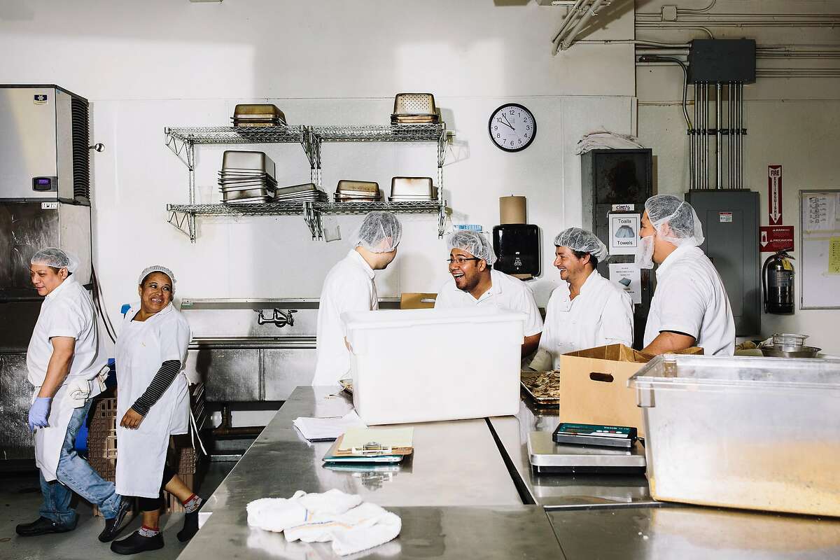 Kitchen workers share a joke inside the Munchery Kitchen in San Francisco, Calif. on Tuesday, April 19, 2016.