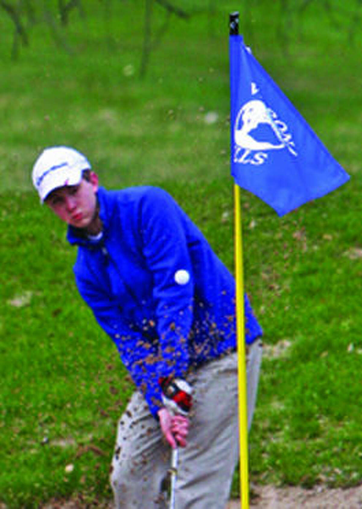 Bad Axe’s Adam Rothe blasts out of a bunker on No. 4 at Verona Hills Golf Club, during the Bad Axe Jamboree, Monday. 
