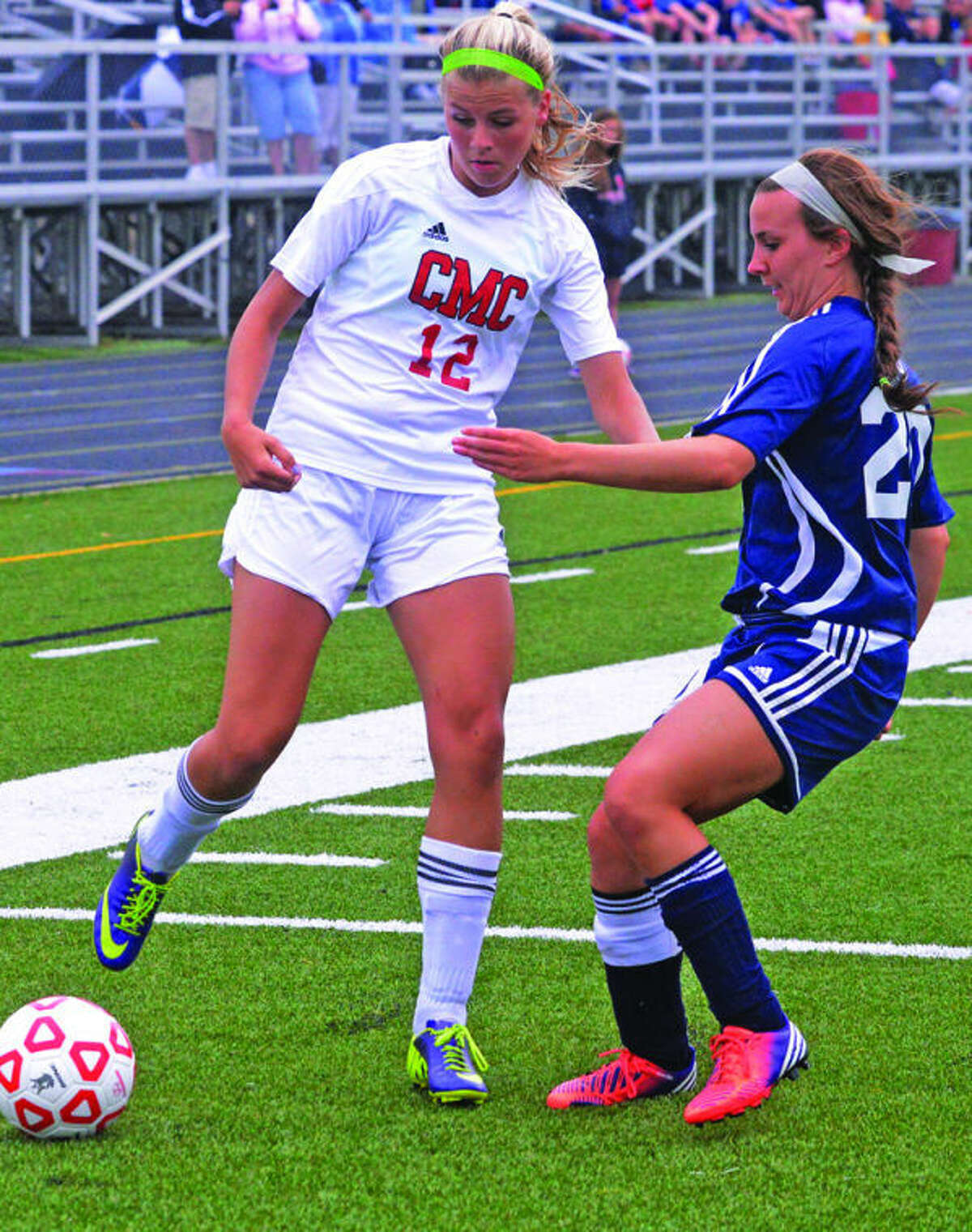 Bad Axe’s Hannah Messing (20) Cardinal Mooney’s Katie Theut (12) play the ball in the first half. 