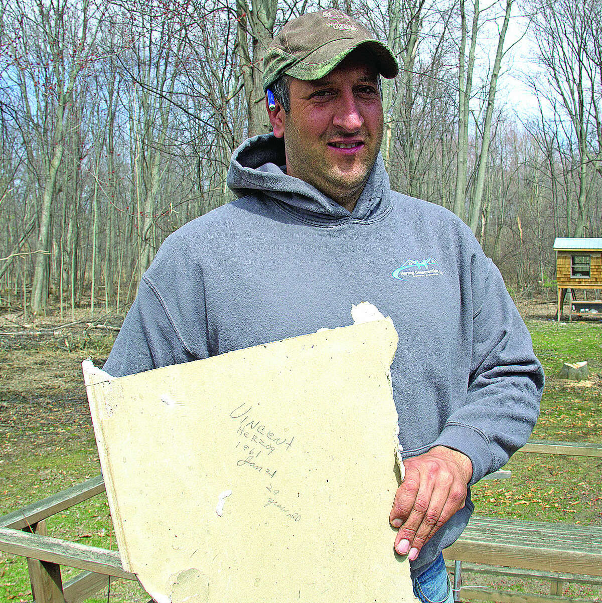 Construction worker Jon Herzog of Pigeon holds a message he uncovered that his late father, Vincent Herzog, wrote in 1961. The message was left in the wall of a Pigeon home — worked on by both Herzogs.