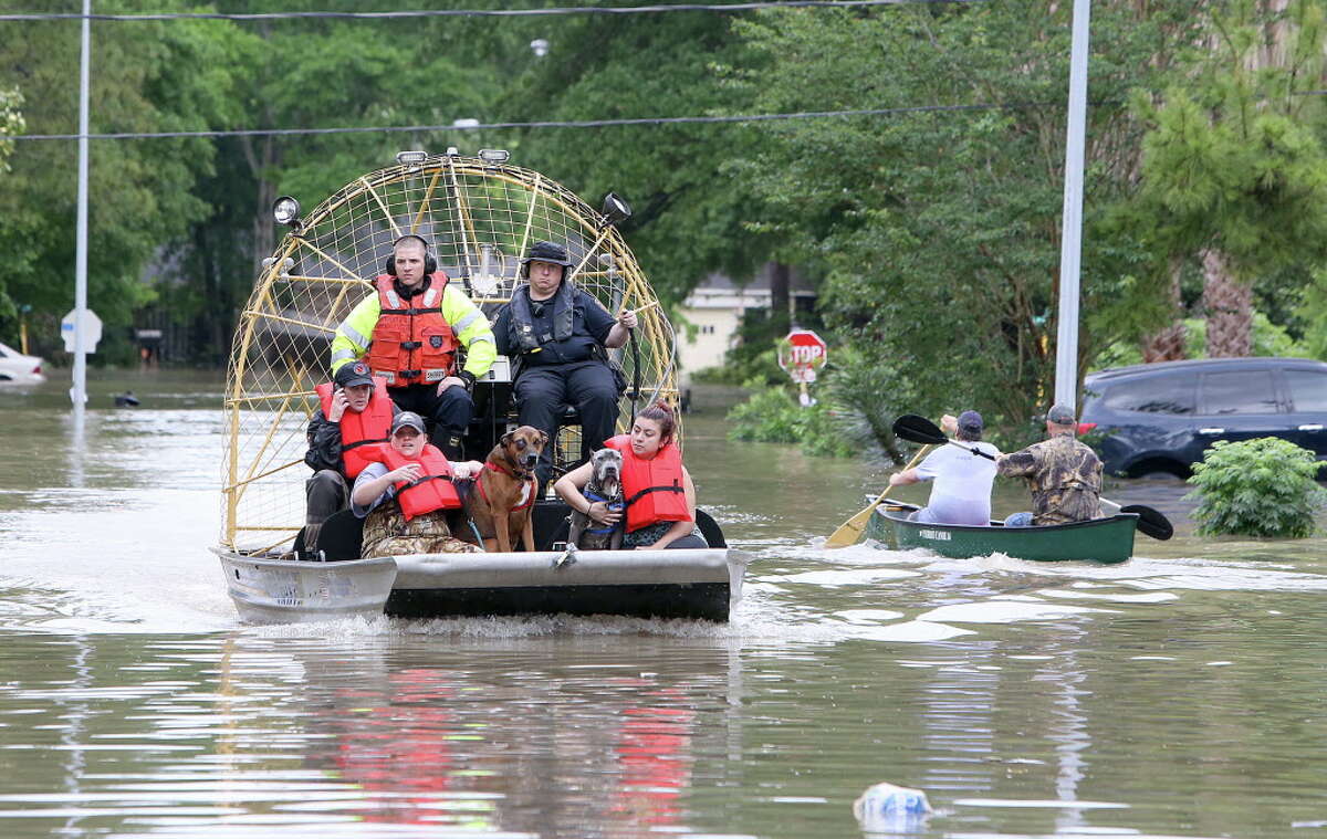 People and their pets are rescued from their homes near Nanes at Baltic in Houston, Texas, Wednesday, April 20, 2016.Thousands of people have been evacuated from their homes and major highways were closed after the rains that started Sunday overwhelmed Houston's bayous. Forecasters have issued another flash flood watch for Houston through Wednesday night. (Steve Gonzales/Houston Chronicle via AP) MANDATORY CREDIT