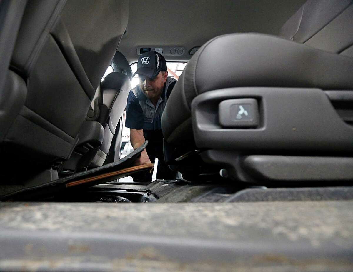 John Eagle Honda technician Shannon Smith checks a spare tire panel in a Honda Odyssey for water.