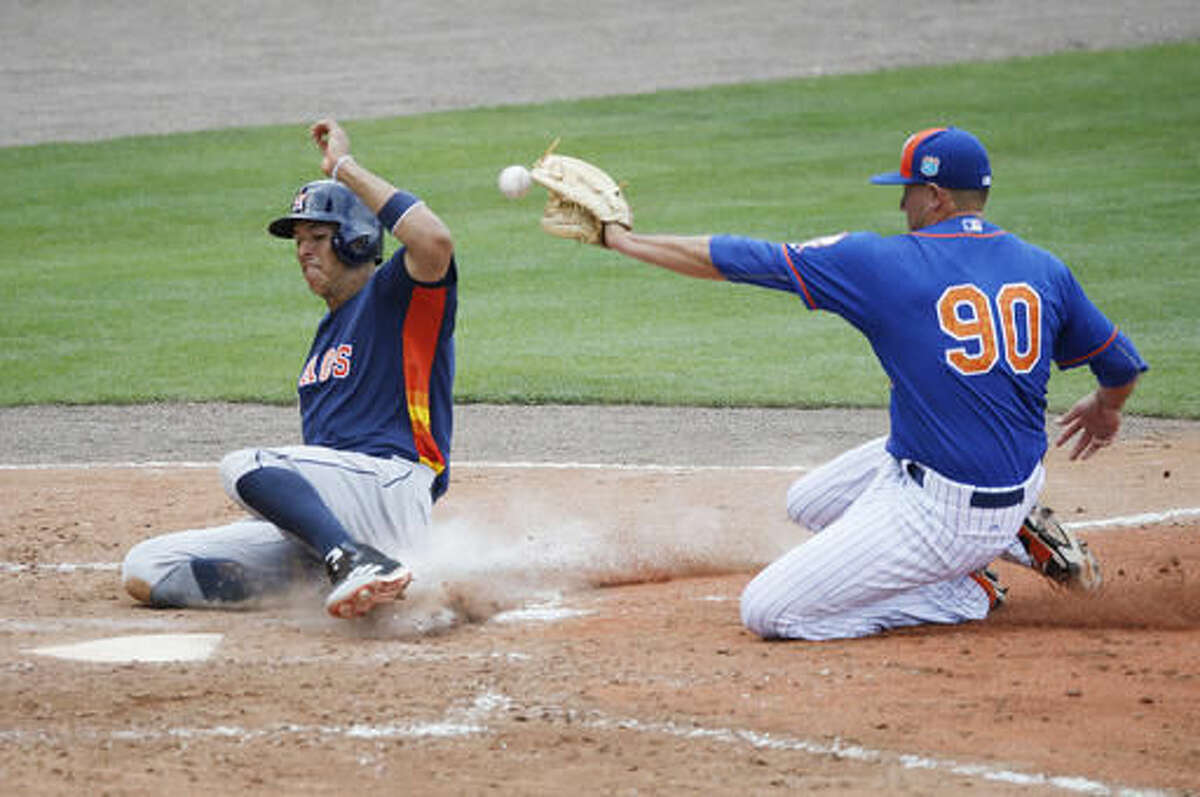 Houston Astros' Carlos Correa, safely slides into home plate after a wild pitch by New York Mets' Beck Wheeler, during the fourth inning of an exhibition spring training baseball game, Thursday, March 24, 2016, in Port St. Lucie, Fla. (AP Photo/Brynn Anderson)