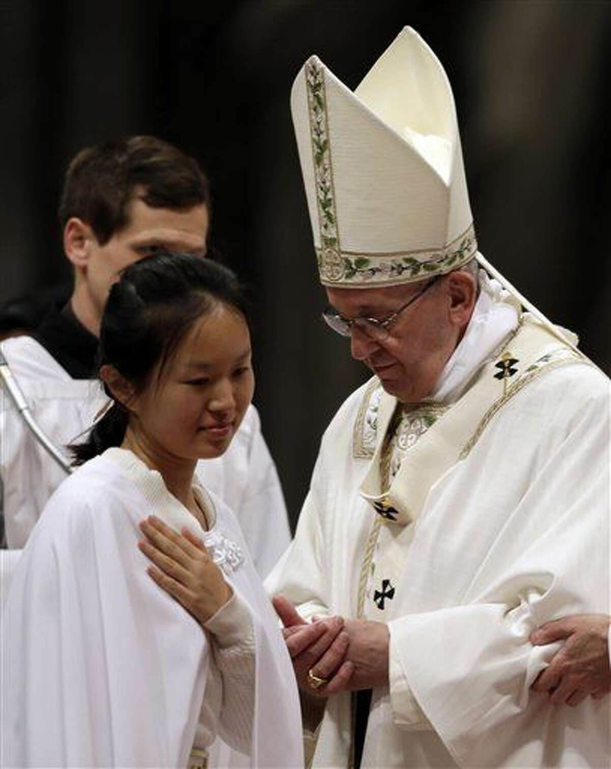 Li Zhang, Mary Stella, of China, walks past Pope Francis after being baptized during an Easter vigil service, in St. Peter's Basilica, at the Vatican, Saturday, March 26, 2016. (AP Photo/Gregorio Borgia)