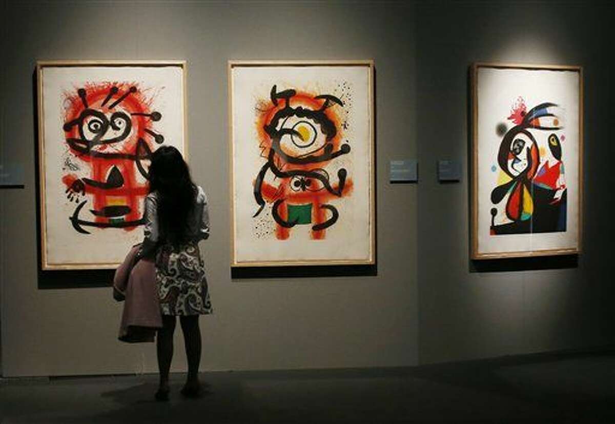 A woman watches paintings during the press preview of the exhibition " Joan Miro - La forza della materia " (The Force of Matter) , a selection of works realized between 1931 and 1981 from the Catalan artist, at the Mudec museum in Milan, Italy, Thursday, March 24, 2016. (AP Photo/Antonio Calanni)