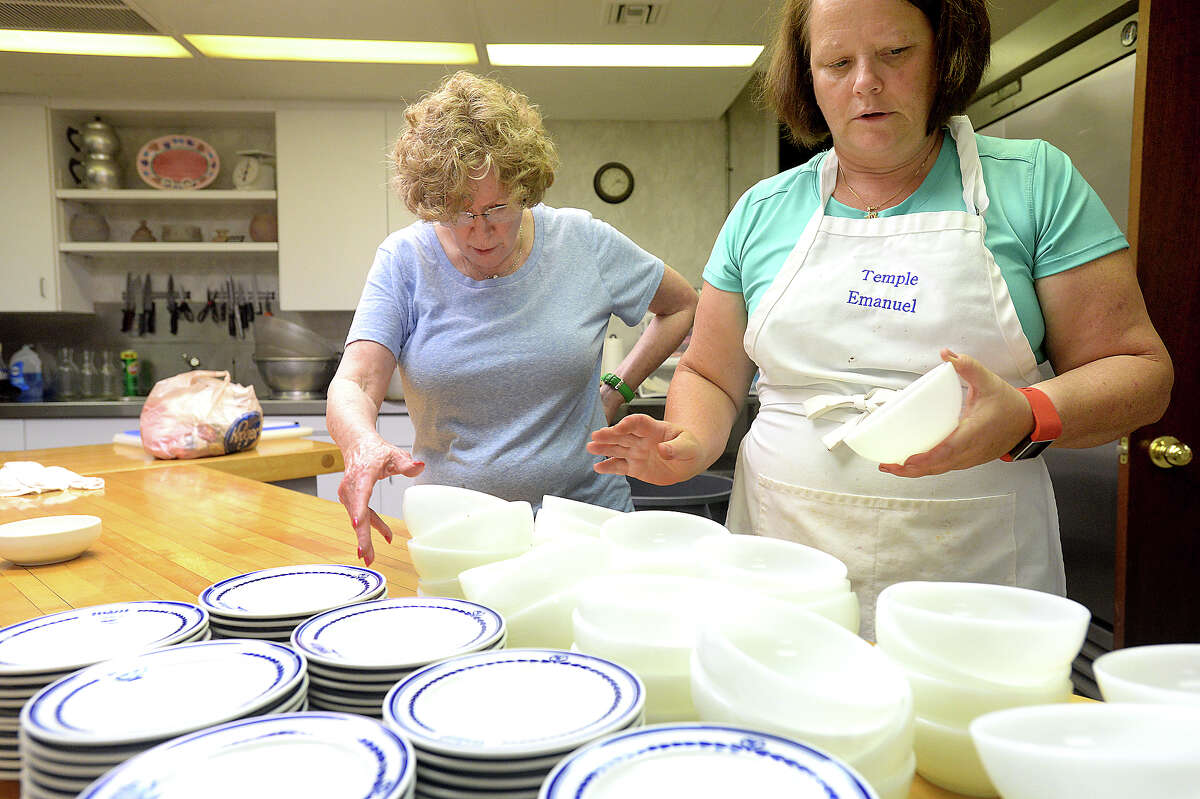 Cheryl Barenberg (right) and Sherry Horwitz count out more than 90 sets of plates and bowls as they continue preparations for Friday's Seder dinner at Temple Emanuel in Beaumont. Friday marks the start of Passover, and the Seder is filled with traditional foods symbolic of the exodus of the Israelites. Photo taken Wednesday, April 20, 2016 Kim Brent/The Enterprise