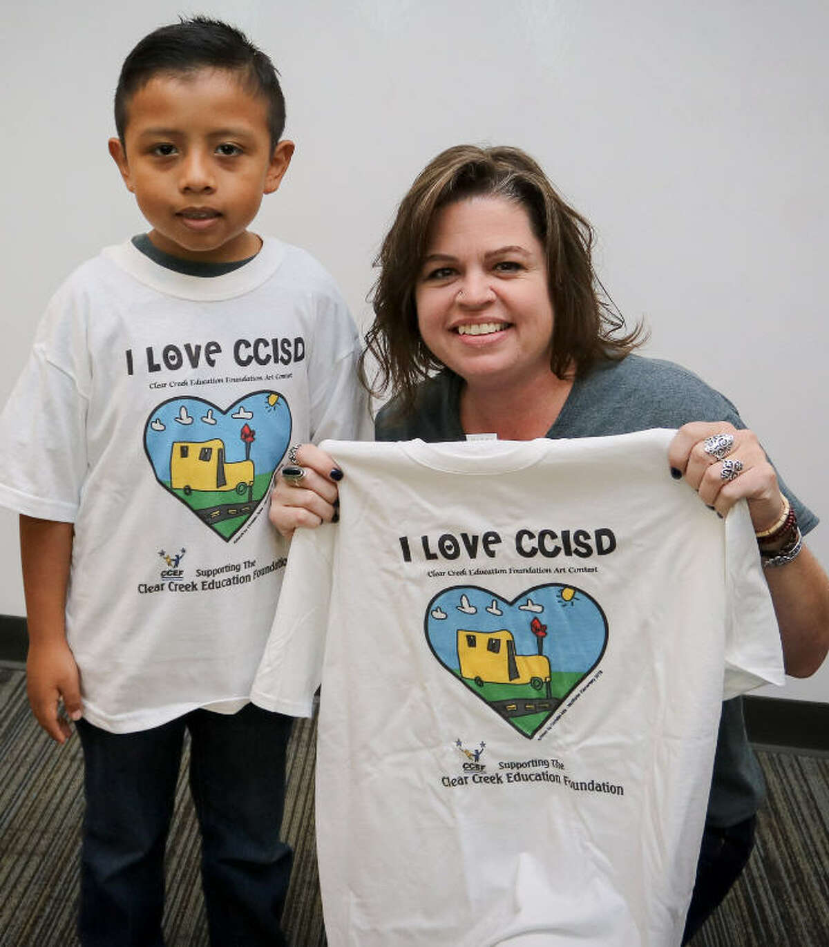 T-shirt art contest winner Christian Ariza Jimenez, from McWhirter Elementary School, and art teacher Leena Elmore showcase his "I Love CCISD" masterpiece.