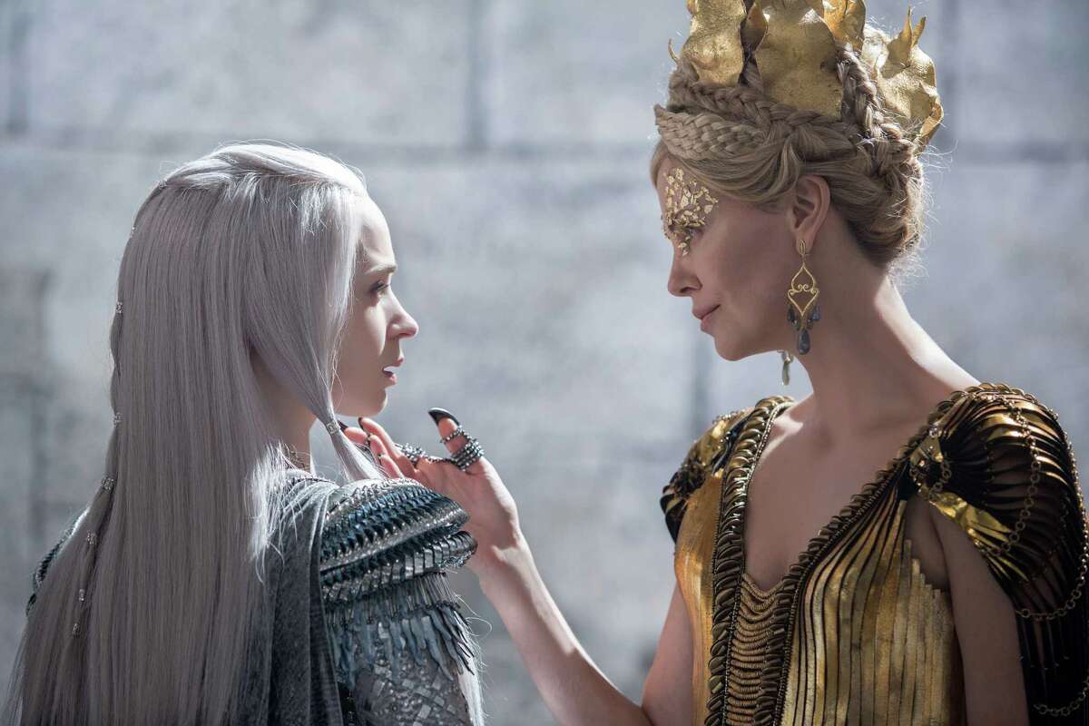 In this image released by Universal Pictures, Emily Blunt, left and Charlize Theron appear in a scene from "Huntsman: Winter's War." (Giles Keyte/Universal Pictures via AP)