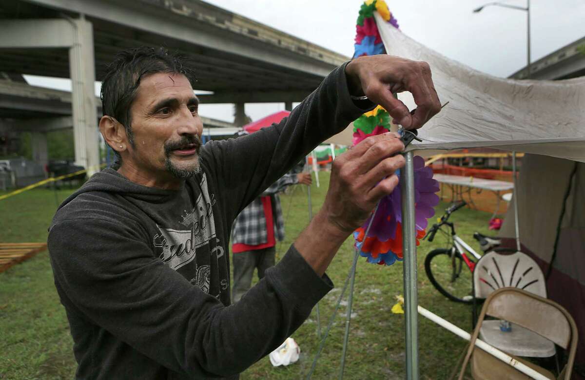 Danny Garcia ties down a tent flap, as he and his uncle Ricardo Garza set up family tents in the rain on Thursday, April 21, 2016, along the parade Fiesta parade route along Broadway under U.S. 281. For the past 28 years seven families have set up at the same location to watch the parades, but the city has sent out notice that this will be the last year. On Tuesday, April 25, 2017, mySA.com confirmed with city officials that camping has been reopened in places along Broadway.