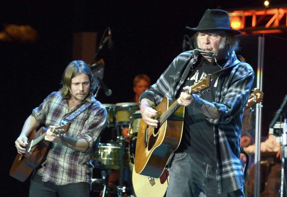 Lukas Nelson (left) backs Neil Young during a benefit concert last year in Mountain View, California.