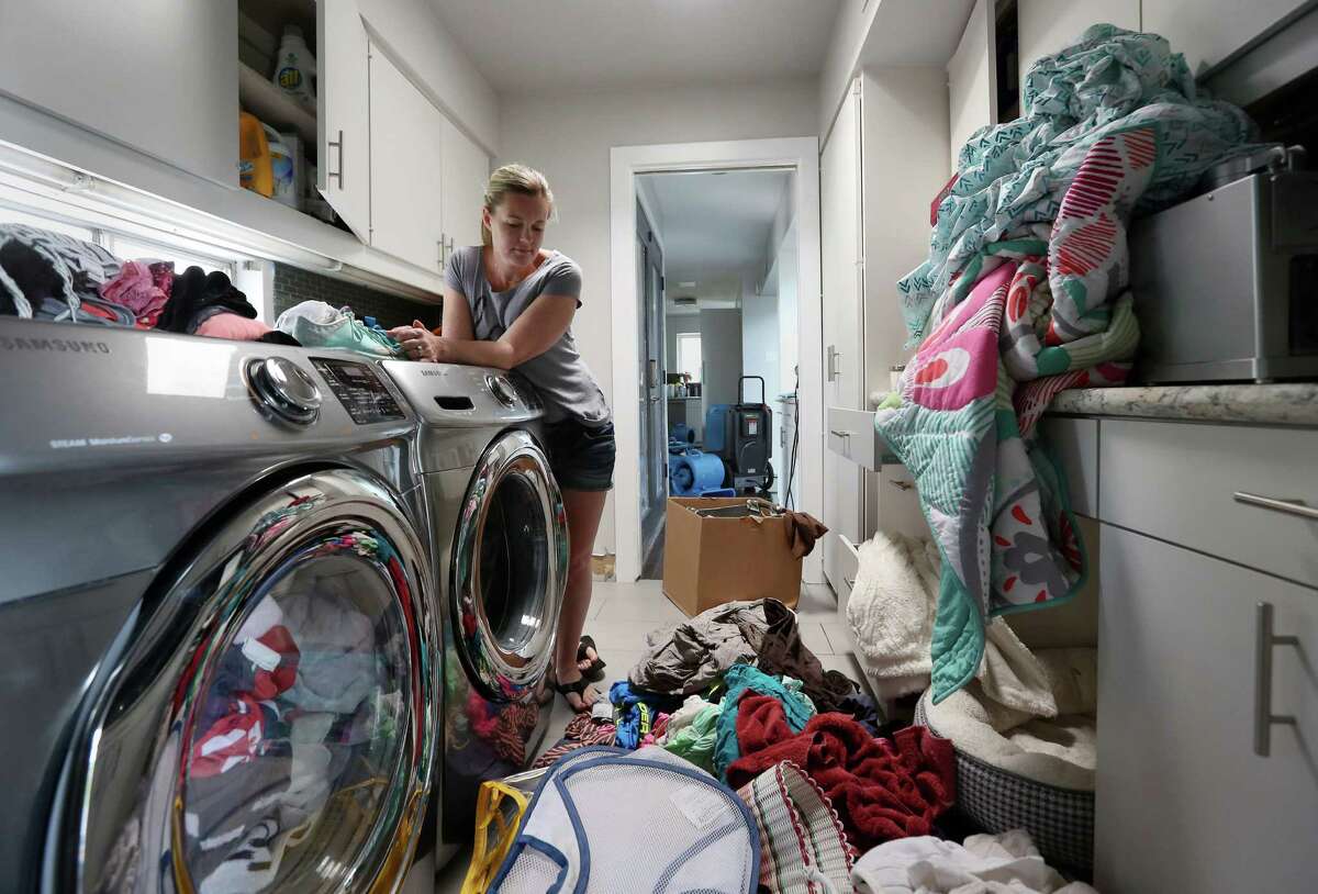 Erin Anders pauses to look at her belongings in the laundry room of her flood-damaged Meyerland home Thursday, April 21, 2016, in Houston. The home has flooded twice in the last year, and Anders cannot afford to rebuild or raise the house. ( Jon Shapley / Houston Chronicle )