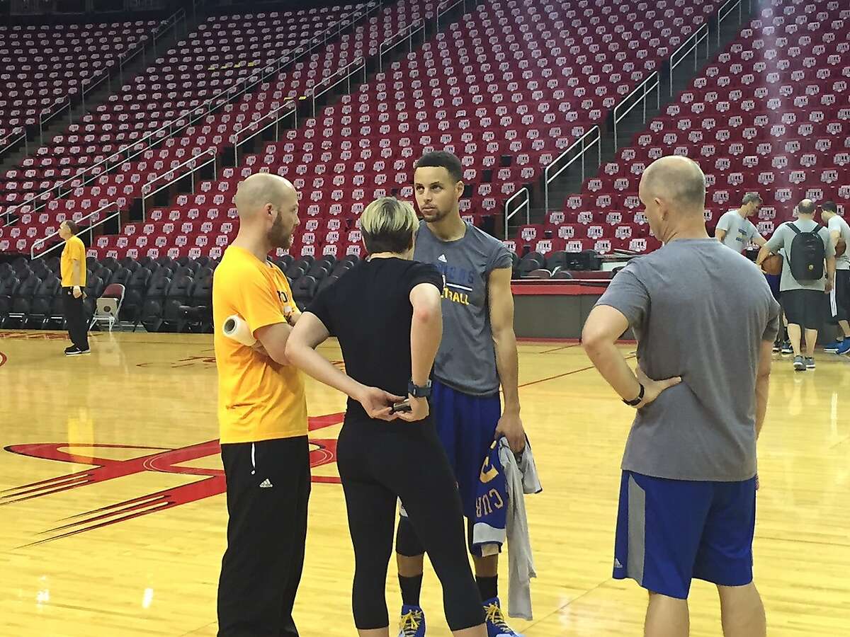 Warriors guard Stephen Curry talks to team trainers Thursday in Houston.