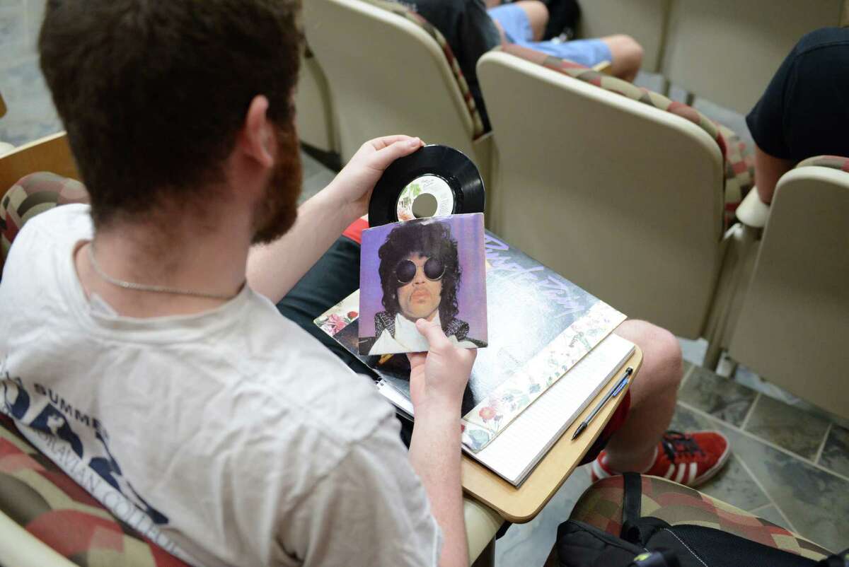 Dan Toland, a student at Union College in Jennifer Matsue?’s history of rock and roll class, examines a single from Prince?’s ?“When Doves Cry?” on Friday, April 22, 2016, at Union College in Schenectady, N.Y. (Will Waldron/Times Union)