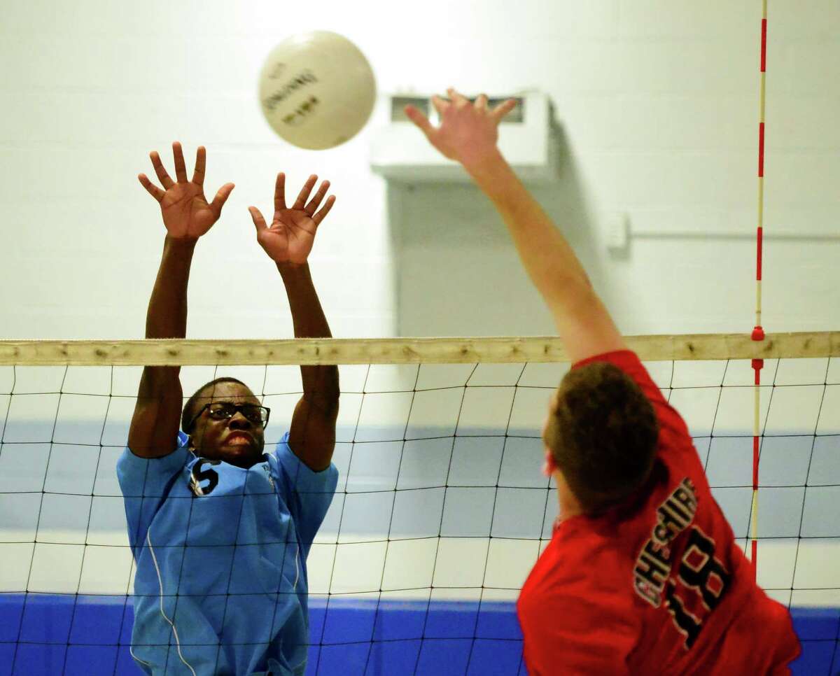 Kolbe Cathedral's Arlande Monrose, left, looks to block a spike by Cheshire's Matt Pinciaro during boys volleyball action in Bridgeport, Conn., on Wednesday Apr. 20, 2016.