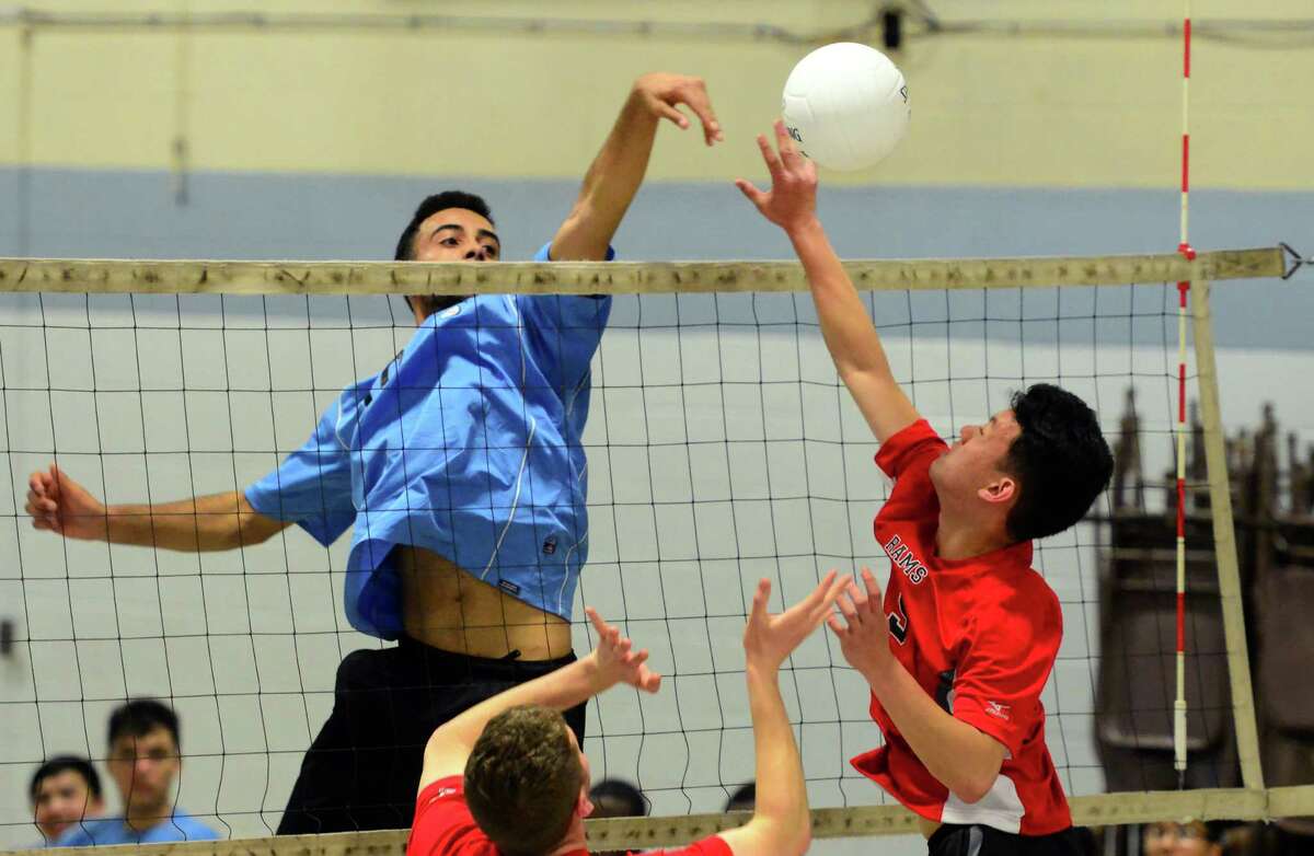 Kolbe Cathedral's Lucas Santiago, left, taps the ball back to Cheshire's Joshua Chen during boys volleyball action in Bridgeport, Conn., on Wednesday Apr. 20, 2016.
