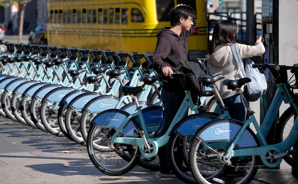 Riders (declined to give names) rent a couple of bikes at the Embarcadero and Ferry building station in San Francisco, California on Sat. April 23, 2016. Bay Area Bike Share is planning to expand into the East Bay adding 1,500 bicycles and 117 new stations.