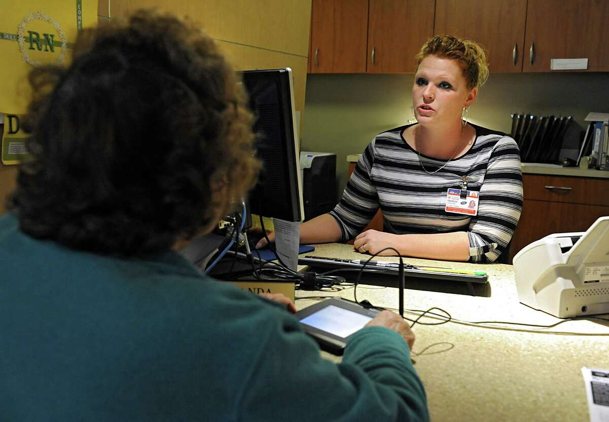 Registration associate Amanda Shader helps a patient at the admissions desk at St. Peter's Hospital on Friday, April 22, 2016 in Albany, N.Y. (Lori Van Buren / Times Union)