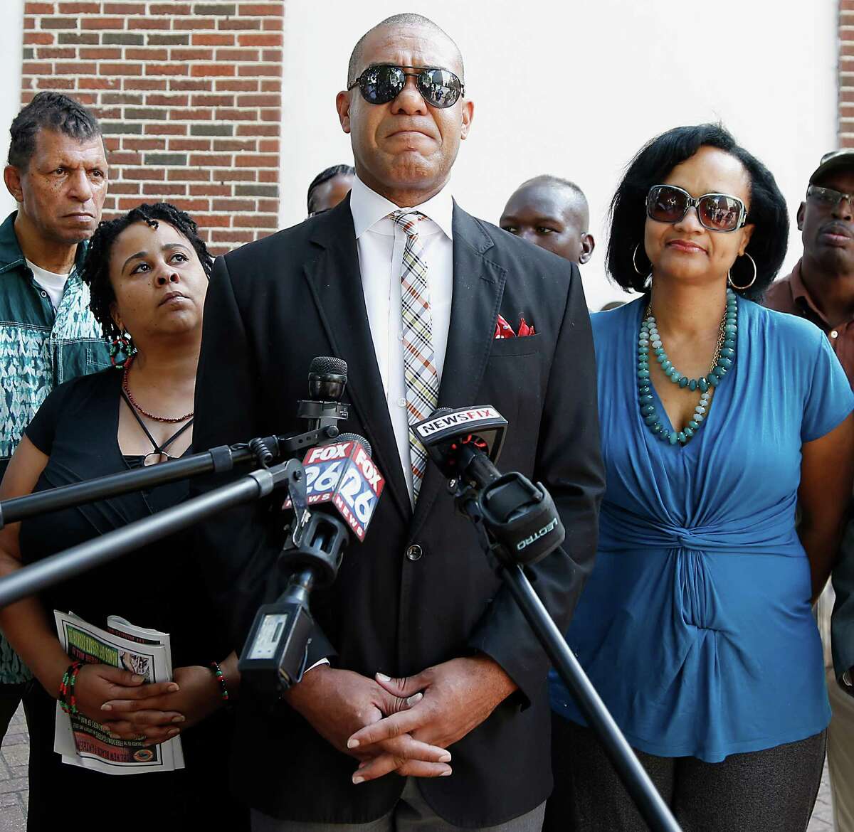 Former Houston City Councilman Jarvis Johnson center, speaks during a press conference as Johnson wife Charlene Johnson right, and Krystal Muhammad left, look on, Johnson was pulled over on September the 13th Johnson by a Precinct 1 Deputy Constable for a traffic violation Thursday, Oct. 9, 2014, in Houston. Johnson says he was held a gunpoint, slapped and robbed of $2,500 cash a Precinct 1 Deputy Constable pulled who Johnson over for allegedly speeding. ( James Nielsen / Houston Chronicle )