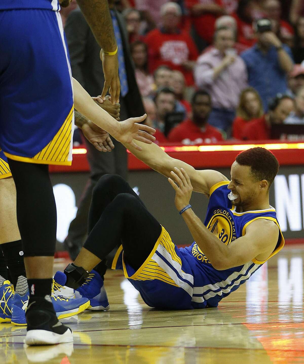 In this Sunday, April 24, 2016 photo, Golden State Warriors guard Stephen Curry (30) is helped up after being injured on the final play during the first half of Game 4 in the first round of the NBA playoff series against the Houston Rockets, in Houston. Golden State's record-setting run toward a second consecutive NBA championship may come down to an MRI on the sprained right knee of Stephen Curry. The NBA's reigning MVP missed the second half of a win over the Houston Rockets in Game 4 on Sunday and was expected to have the medical test later Monday. (Karen Warren/Houston Chronicle via AP) MANDATORY CREDIT