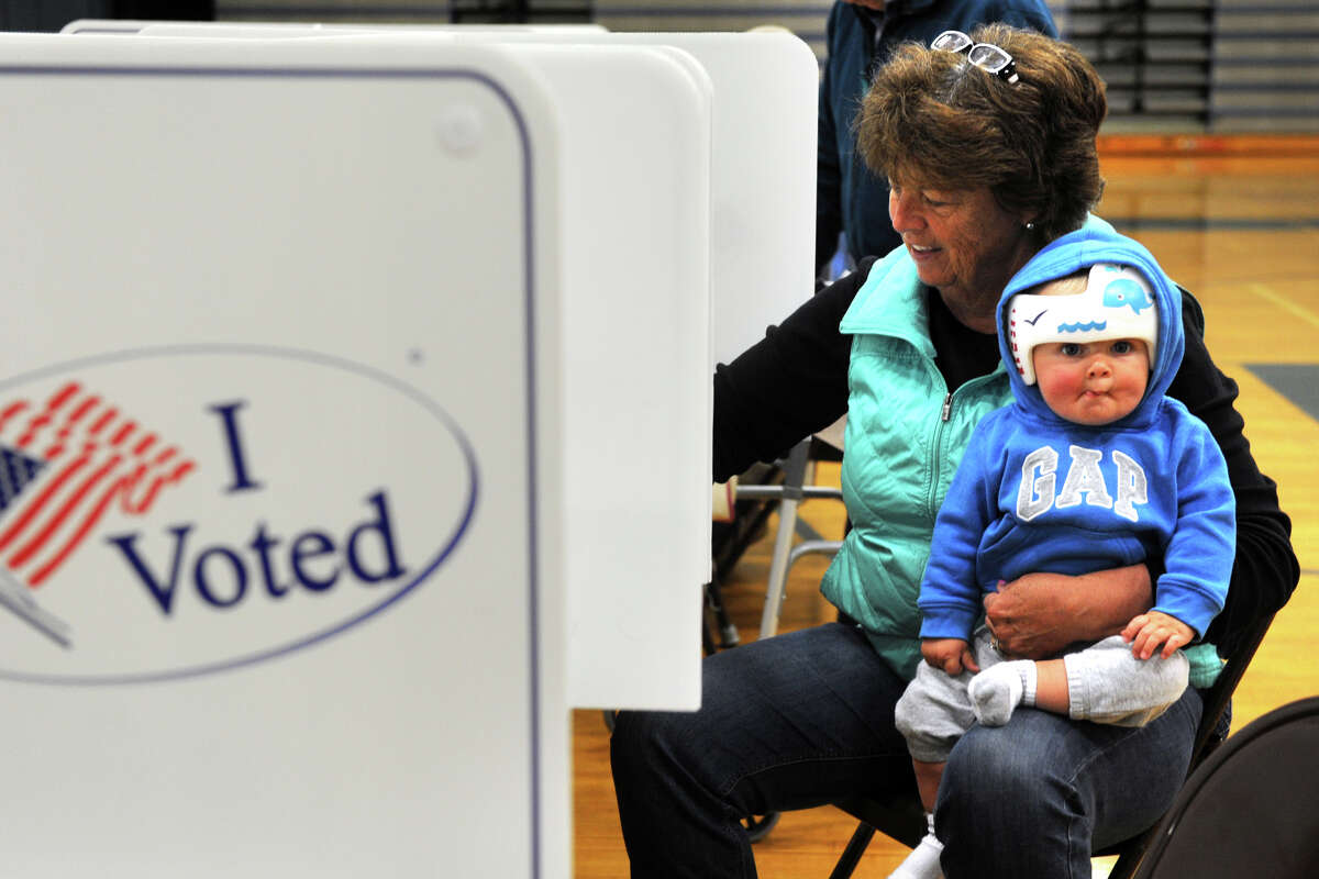 Susan Lance holds her 8-month old grandson, Oliver Carlton, as she casts her vote in the presidential primary at Bunnell High School, in Stratford, Conn. April 26, 2016.