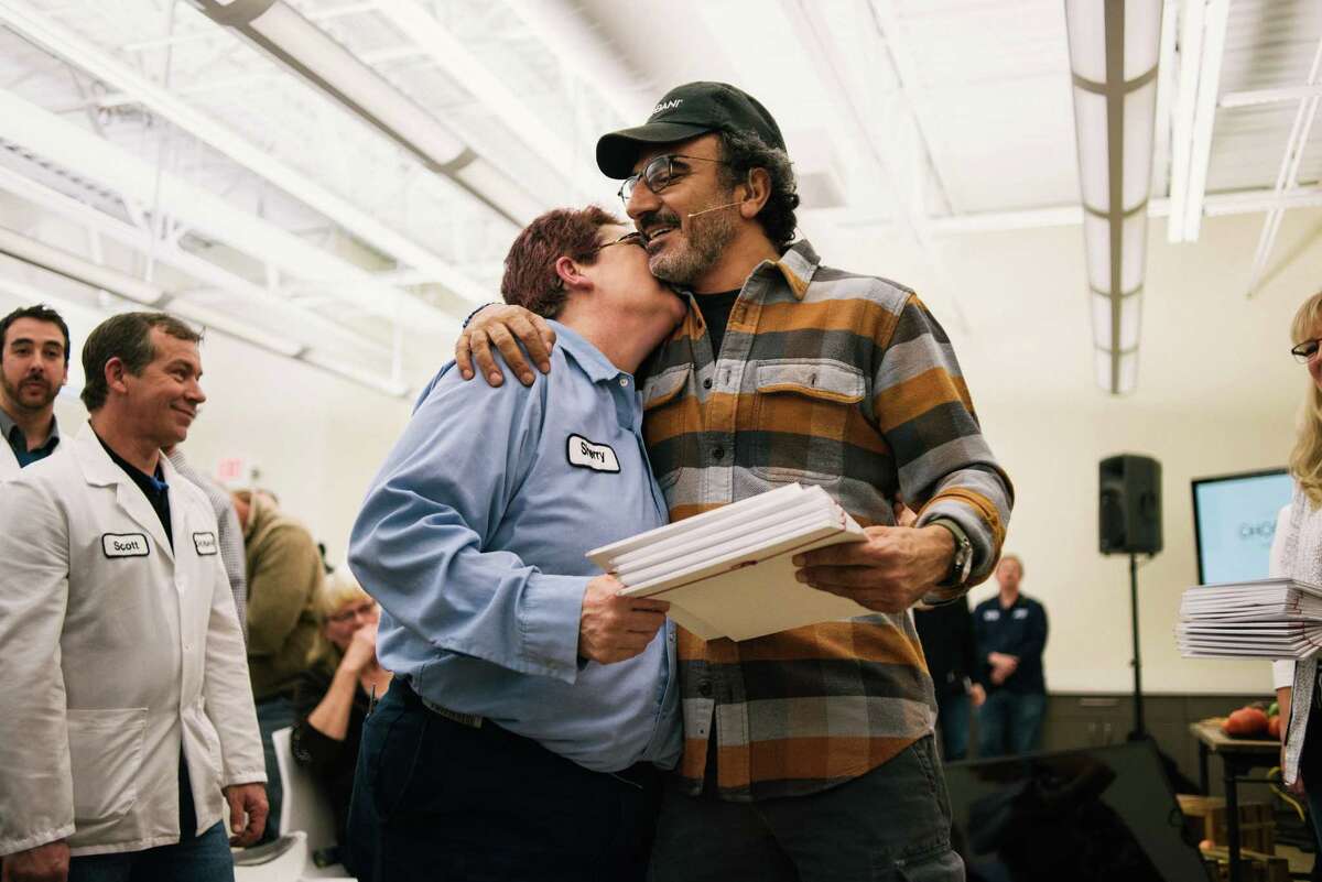 Hamdi Ulukaya, right, a Turkish immigrant who founded the yogurt company Chobani in 2005, with employees after announcing that he was giving them shares worth up to 10 percent of the company when it goes public or is sold, in New Berlin, N.Y., April 26, 2016. The ownership stake in the yogurt company could make some of the 2,000 full-time employees into millionaires. (Alexandra Hootnick/The New York Times) ORG XMIT: XNYT104