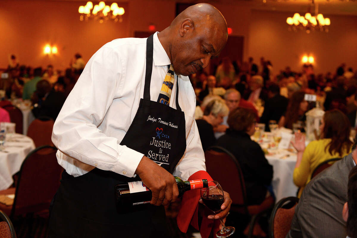 Judge Terrance Holmes serves wine during the CASA Justice is Served dinner at the MCM Elegante Hotel on Tuesday evening. The event, now in its tenth year, raises money of the Court Supported Special Advocates program, which has volunteers help children in foster care. This year's dinner was held in memory of Judges Lupe Flores and John Paul Davis. Photo taken Tuesday 4/26/16 Ryan Pelham/The Enterprise