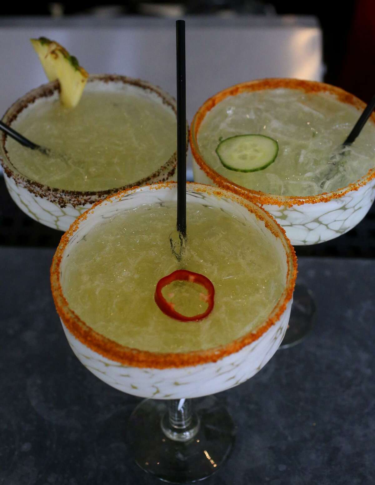 Drinks made from infused spirits at The Frutería-Botanero on South Flores Street include the "pepino" margarita (top, right) with a cucumber infusion, the gin drink infused with fresno pepper and orange skin (center, bottom) and the Piña Mezcal infused with orange and pineapple (top, left).