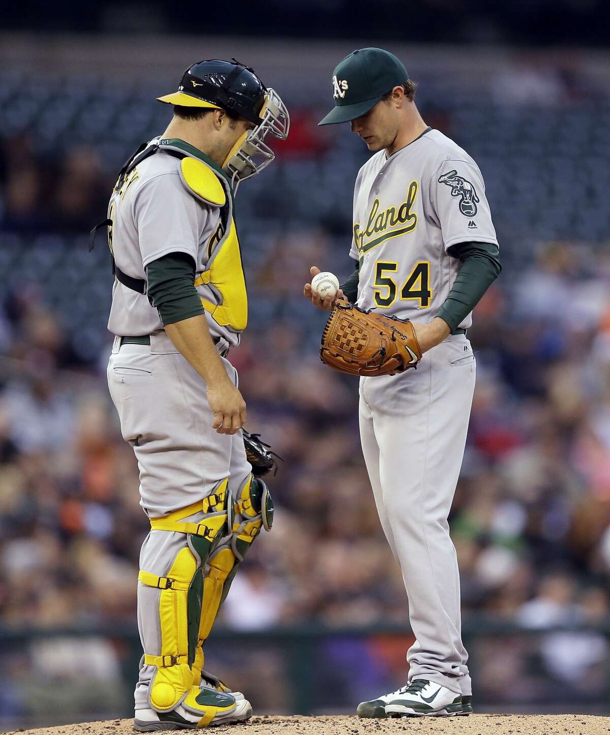 Oakland Athletics catcher Josh Phegley talks with starting pitcher Sonny Gray (54) on the mound during the second inning of a baseball game against the Detroit Tigers, Wednesday, April 27, 2016, in Detroit. (AP Photo/Carlos Osorio)