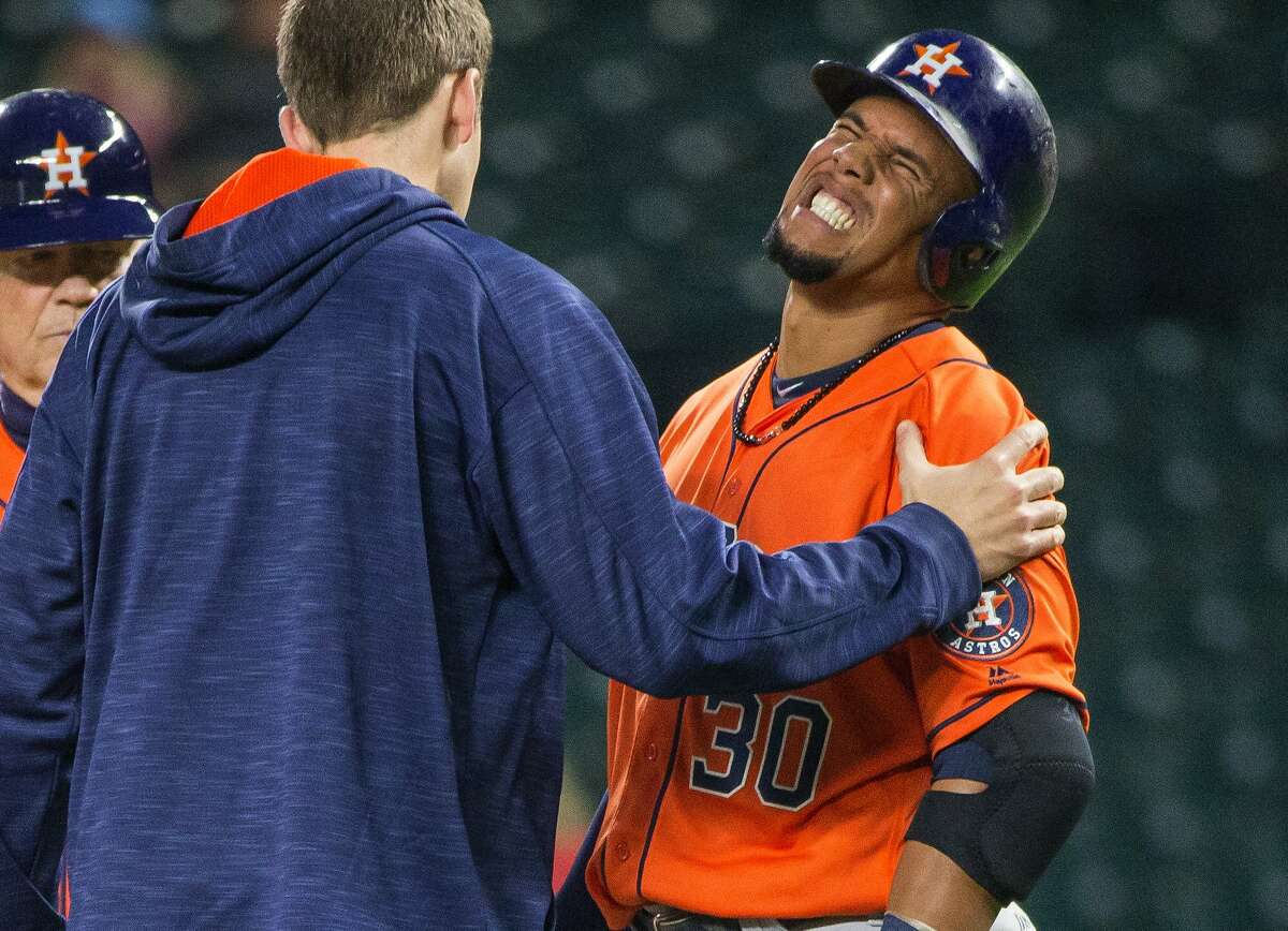 A trainer comes to the aid of Houston Astros' Carlos Gomez, who was hit by a pitch from Seattle Mariners' Hisashi Iwakuma during the fourth inning of a baseball game Wednesday, April 27, 2016, in Seattle. (Dean Rutz/The Seattle Times via AP)