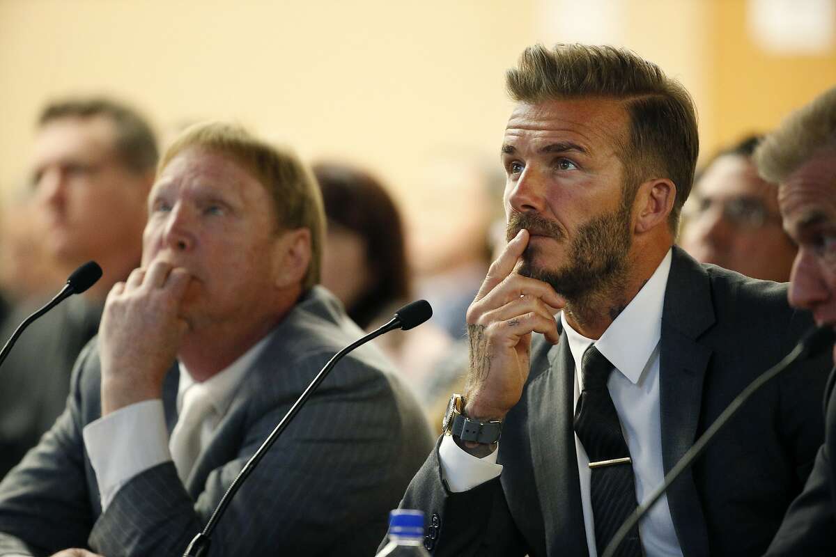 Former soccer player David Beckham, right, and Oakland Raiders owner Mark Davis, left, listen at a meeting of the Southern Nevada Tourism Infrastructure Committee, Thursday, April 28, 2016, in Las Vegas. Mark Davis says he wants to move the team to Las Vegas and is willing to spend a half billion dollars as part of a deal for a new stadium in the city. (AP Photo/John Locher)