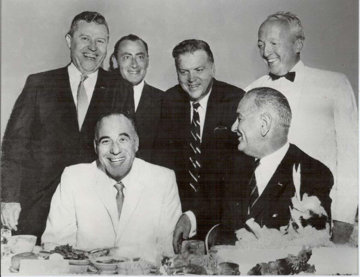 Bill Sinkin (standing, second from left) poses with Texas politicos including President Lyndon Johnson (seated, right), Rep. Henry B. Gonzalez (seated, left), Sen. Ralph Yarborough (standing left), attorney John Daniels and J. Edward Day, former postmaster general.