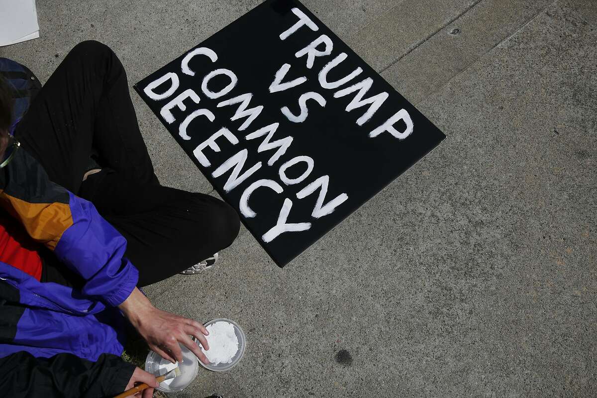 Protester Brandon finishes up painting a sign outside of the Hyatt Regency during the first day of the California Republican Party Convention which featured speeches from Presidential candidates Donald Trump and John Kasich among others April 29, 2016 in Burlingame, Calif.