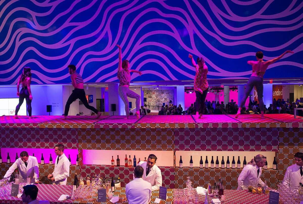 Dancers perform on top of the bar for guests of Art Bash, a party to celebrate the reopening of the San Francisco Museum of Modern Art after it's renovation and expansion, during the event at the museum in San Francisco on Friday, April 29, 2016. The museum opens to the public on May 14.