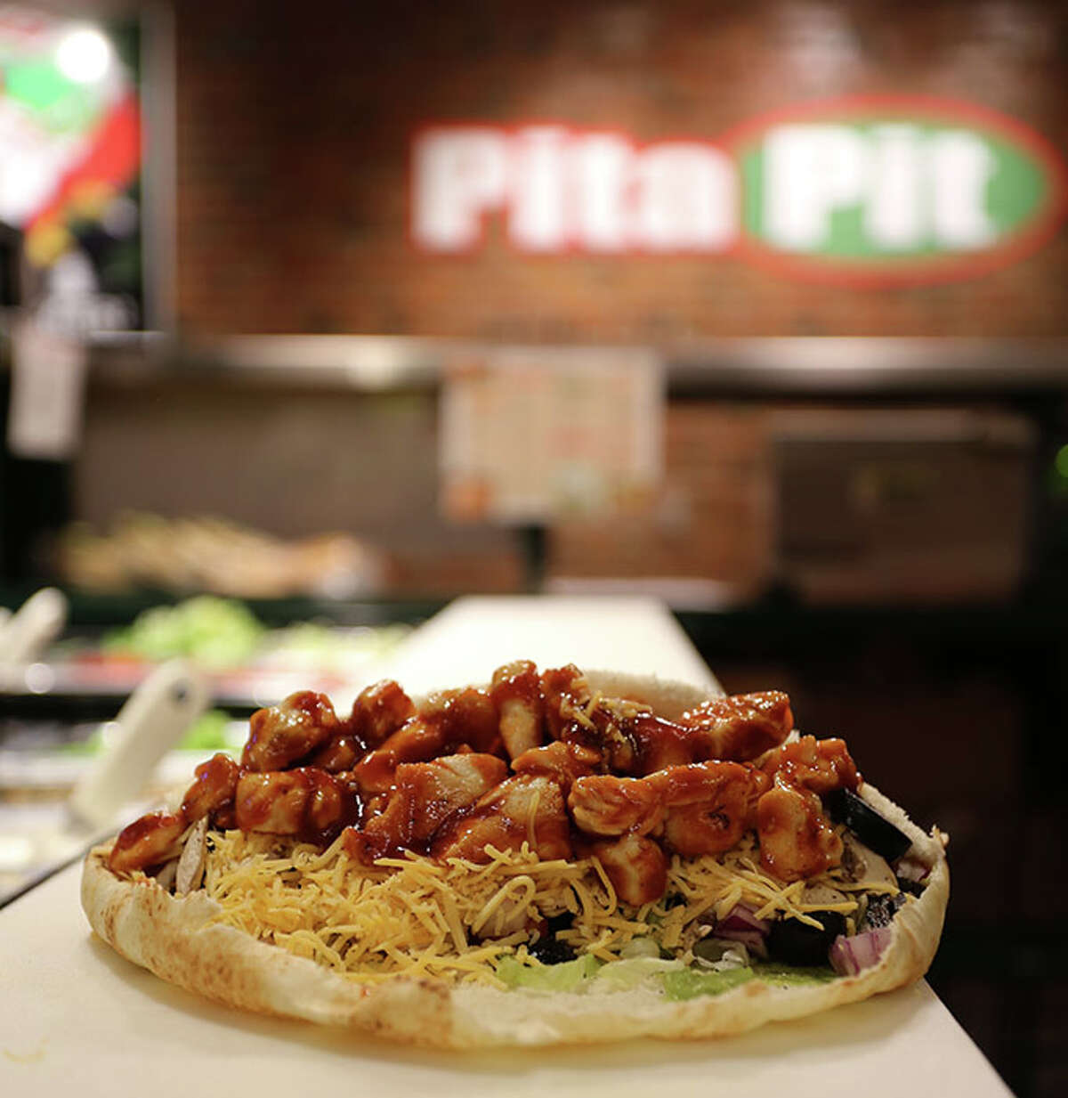 Buffalo chicken is on the menu at Pita Pit. Patrons can customize their pitas by selecting a variety of ingredients as they go through the line.