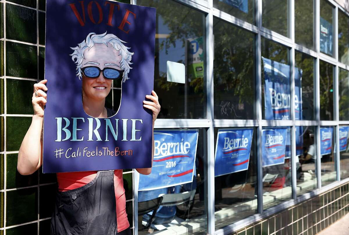 Kelly Blondin holds a mask for a photo taken by a friend at the opening of the Bay Area headquarters for the Bernie Sanders presidential campaign in Oakland, Calif. on Saturday, April 30, 2016.