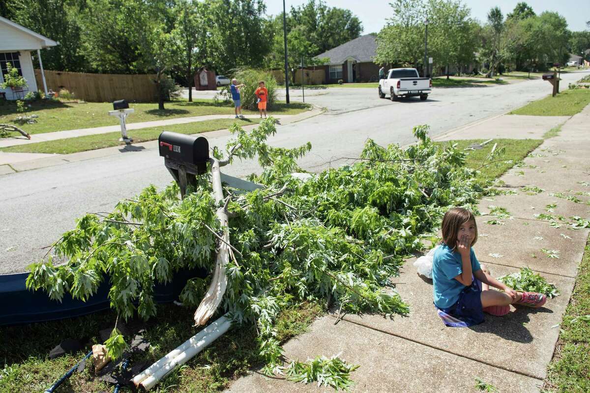 Stella Quintero, 6, sits on the sidewalk collecting fallen leaves in front of her home in the Woodlands neighborhood of Lindale, Texas Saturday, April 30, 2016. A suspected tornado came through the area Friday night. (Sarah A. Miller/Tyler Morning Telegraph via AP) MANDATORY CREDIT