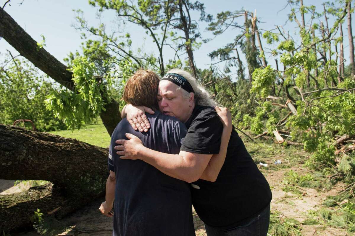 Neighbors Mary Anderson, left, and Jennifer Casebeer, right, embrace Saturday April 30, 2016 after a suspected tornado hit both their homes in Lindale, Texas. Tornados have snaked across northern and eastern Texas and southern Oklahoma, causing severe damage, including fallen tree limbs and power lines that are slowing first-responders. (Sarah A. Miller/Tyler Morning Telegraph via AP) MANDATORY CREDIT